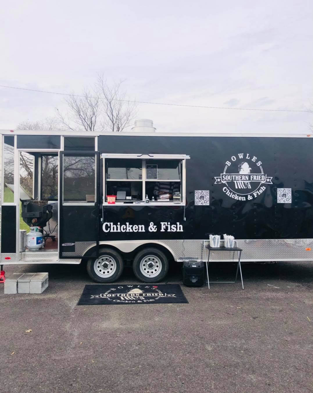 A black food truck with the name