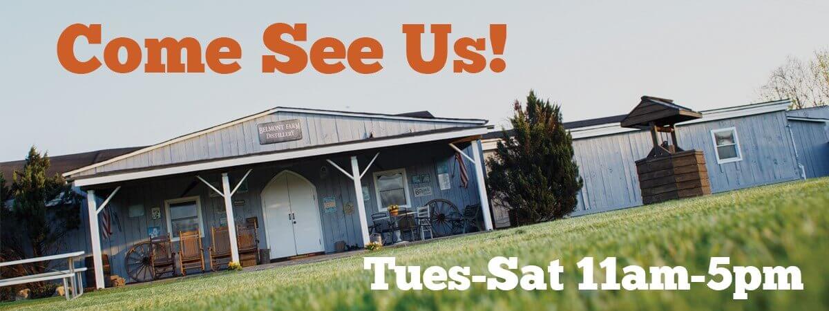 A wooden building with a porch and chairs sits under a large orange and white sign that reads 