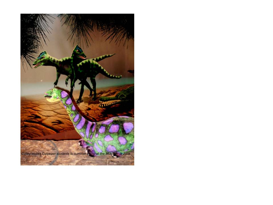 Three dinosaur figurines are set against a prehistoric-looking backdrop. In the foreground, a small green and purple dinosaur is in sharp focus, while two larger, darker dinosaurs are in the background. Text at the bottom is partially visible.