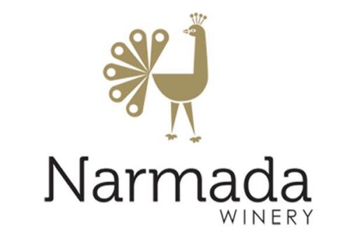 Logo of Narmada Winery featuring a stylized illustration of a peacock in gold color, positioned above the text 