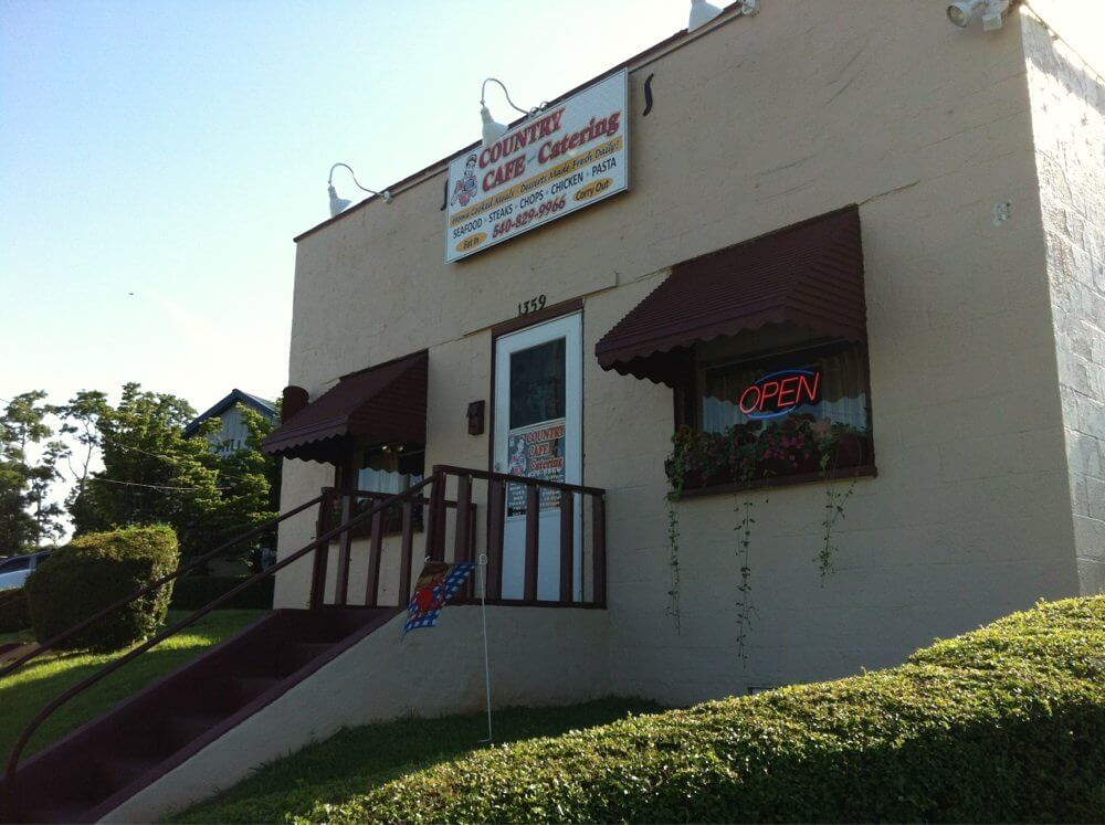 A small café with a beige exterior and a sign that reads 