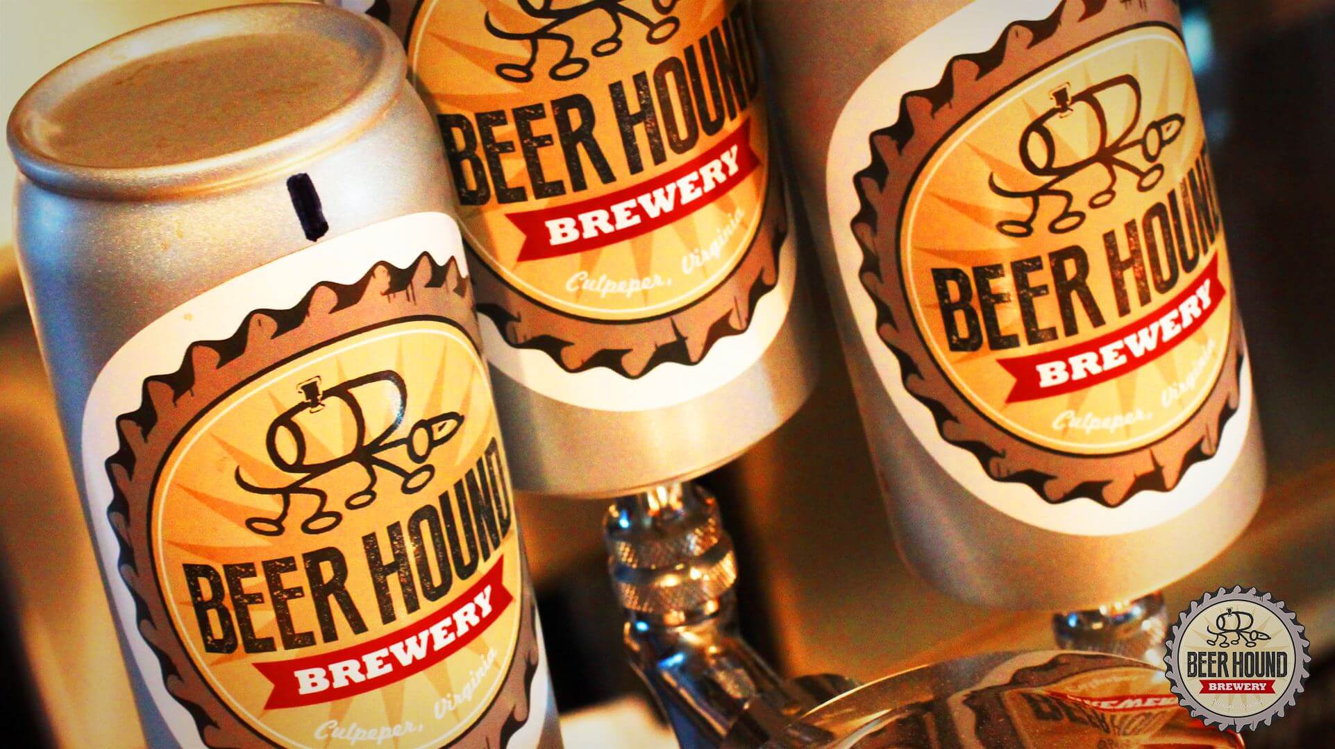 Close-up of beer cans from Beer Hound Brewery. The cans feature a yellow and brown label with the brewery's logo—a dog with a beer mug—along with 