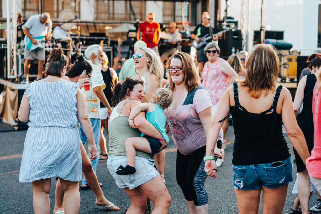 group of people at a concert dancing and smiling